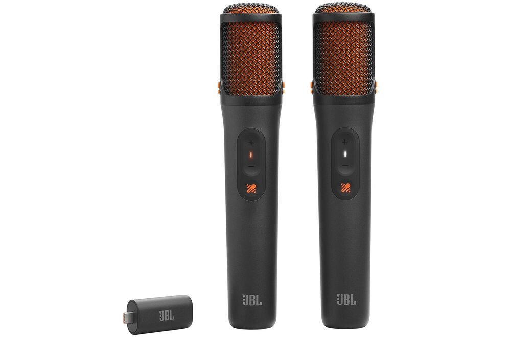 Na obrazie znajdują się dwa czarne mikrofony z pomarańczową siatką oraz mały adapter. Na każdym mikrofonie widoczne jest logo \'JBL\'.