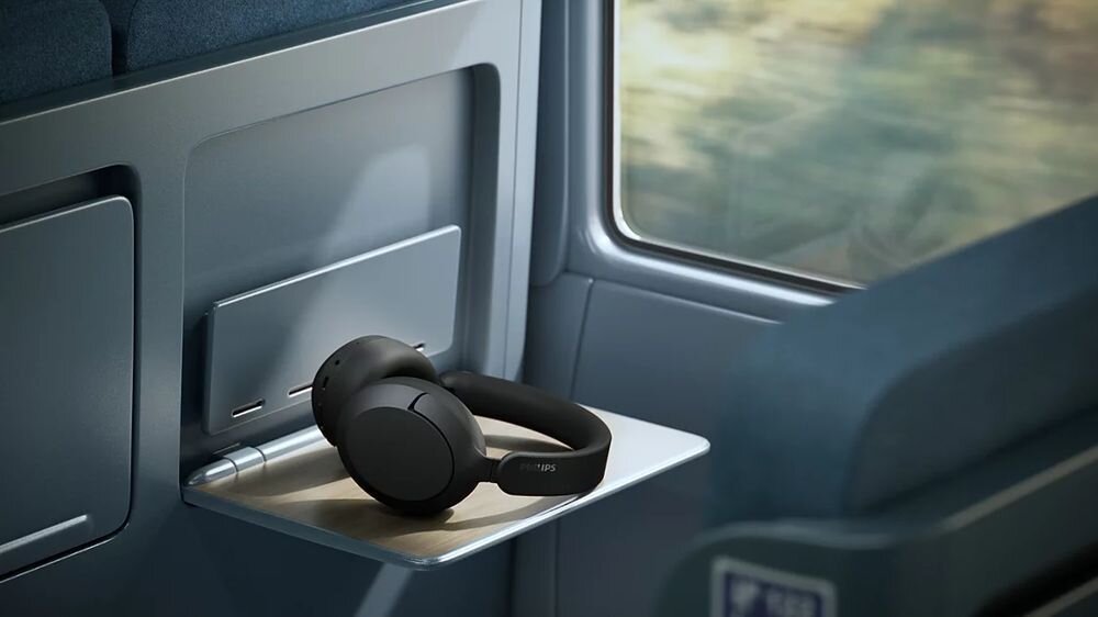 Słuchawki nauszne PHILIPS TAH6000BK ANC, ciepłe brzmienie Philips, szczegóły dźwięku, głęboki bas, słuchawki leżące na blacie w pociągu