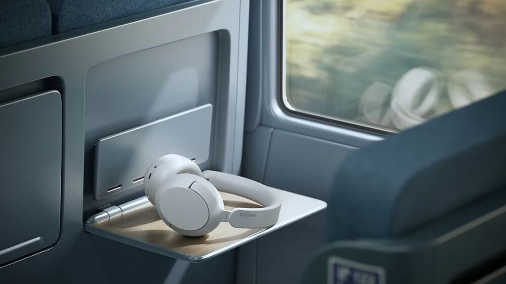 Słuchawki nauszne PHILIPS TAH6000WT ANC, ciepłe brzmienie Philips, szczegóły dźwięku, głęboki bas, słuchawki leżące na blacie w pociągu