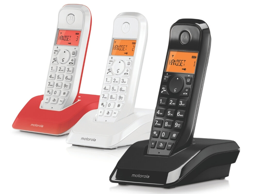 Trzy bezprzewodowe telefony stacjonarne w kolorach czerwonym, białym i czarnym, każdy z wyświetlaczem pokazującym tekst \'HANDSET\'. Na podstawach telefonów widoczne jest logo \'motorola\'.