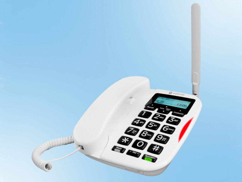 Biały telefon stacjonarny z dużymi przyciskami numerycznymi i wyświetlaczem LCD pokazującym godzinę 13:06. Na obudowie widoczne jest logo \'motorola\'.