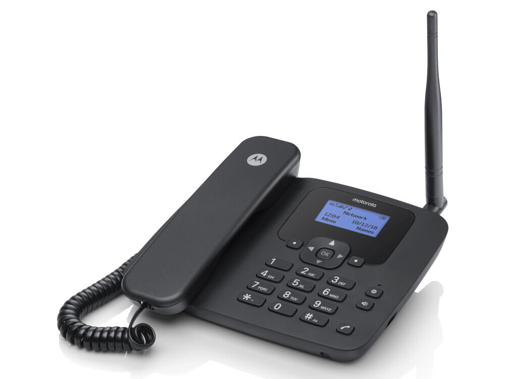 Czarny telefon stacjonarny z wyświetlaczem LCD, klawiaturą numeryczną i anteną. Na wyświetlaczu widoczny jest tekst: \'motorola\', \'12:09\', \'Menu\', \'10/12/18\', \'Kontakt\'.