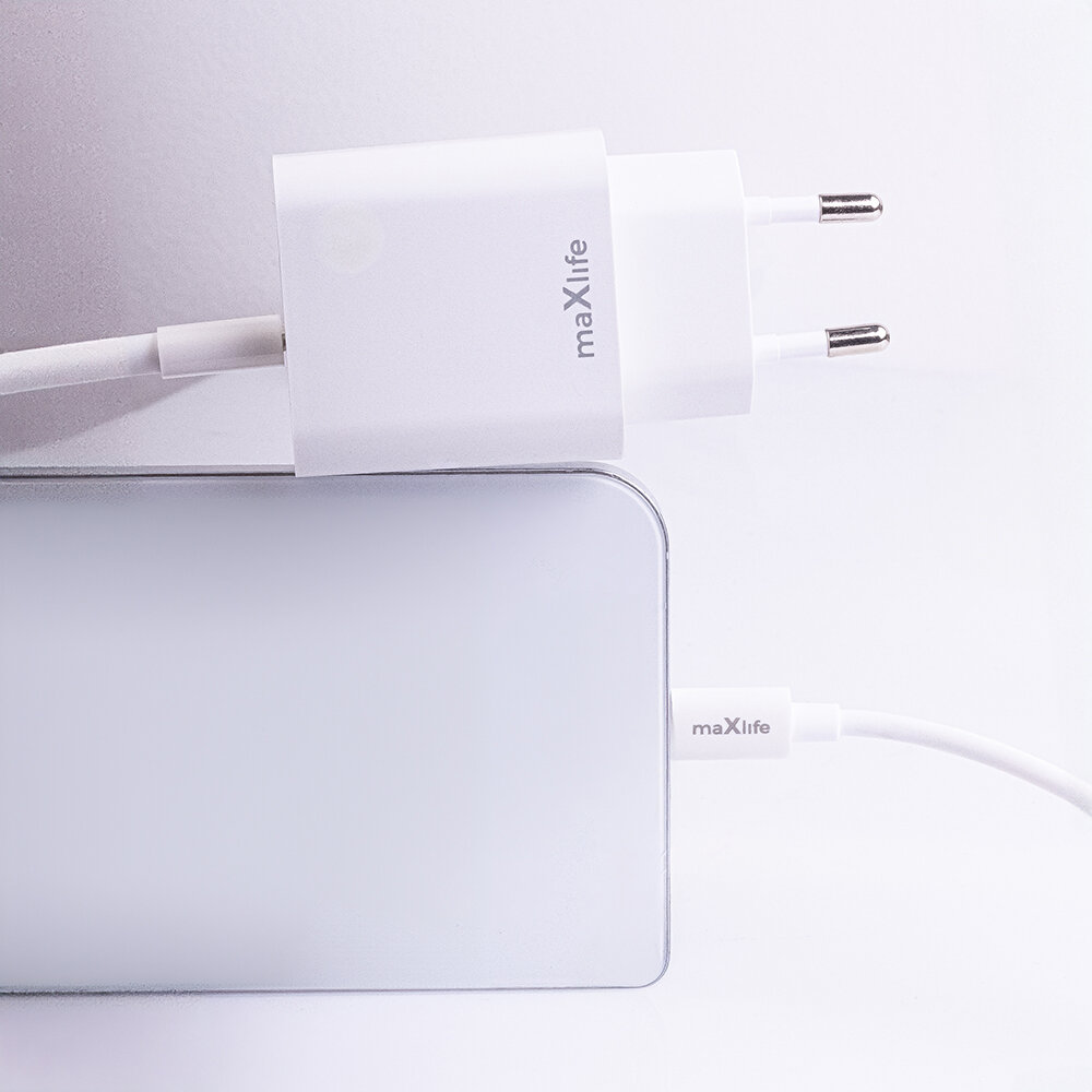 Biała ładowarka sieciowa z logo \'maxlife\' podłączona do urządzenia za pomocą kabla USB-C. Widoczne są dwa metalowe bolce wtyczki oraz fragment kabla z napisem \'maxlife\'.