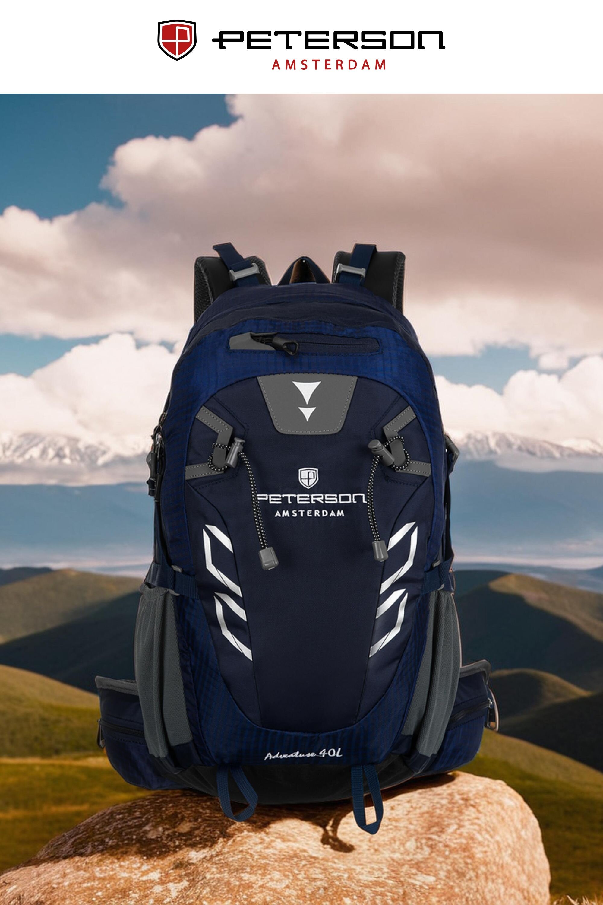Granatowy plecak turystyczny z logo \'Peterson Amsterdam\' i napisem \'Mountain 40L\' na tle górskiego krajobrazu. Na górze obrazu widoczne jest logo i napis \'PETERSON AMSTERDAM\'.