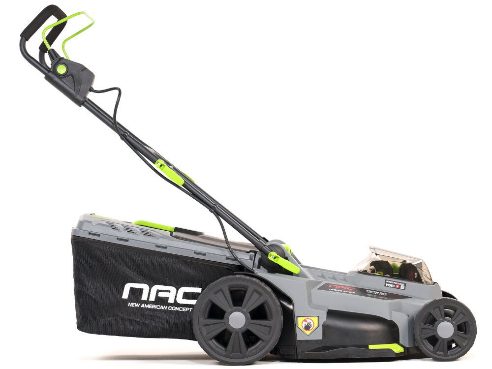 Na obrazie widoczna jest szara kosiarka akumulatorowa z czarnymi kołami i zielonymi elementami. Na boku znajduje się logo \'NAC\' oraz napis \'NEW AMERICAN CONCEPT\'.