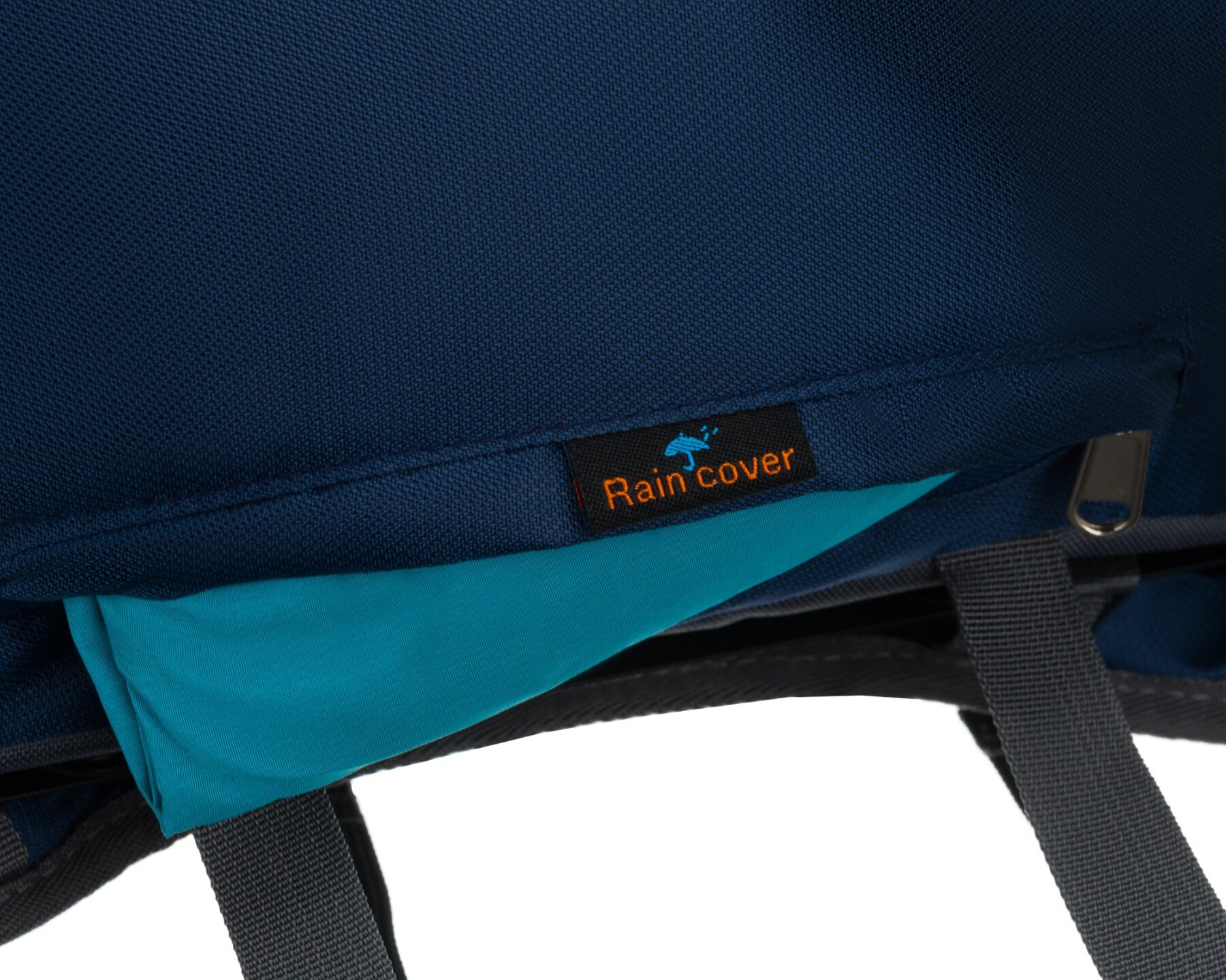 Granatowy materiał plecaka z widocznym niebieskim pokrowcem przeciwdeszczowym. Na materiale znajduje się czarna metka z pomarańczowym napisem \'Rain cover\'.