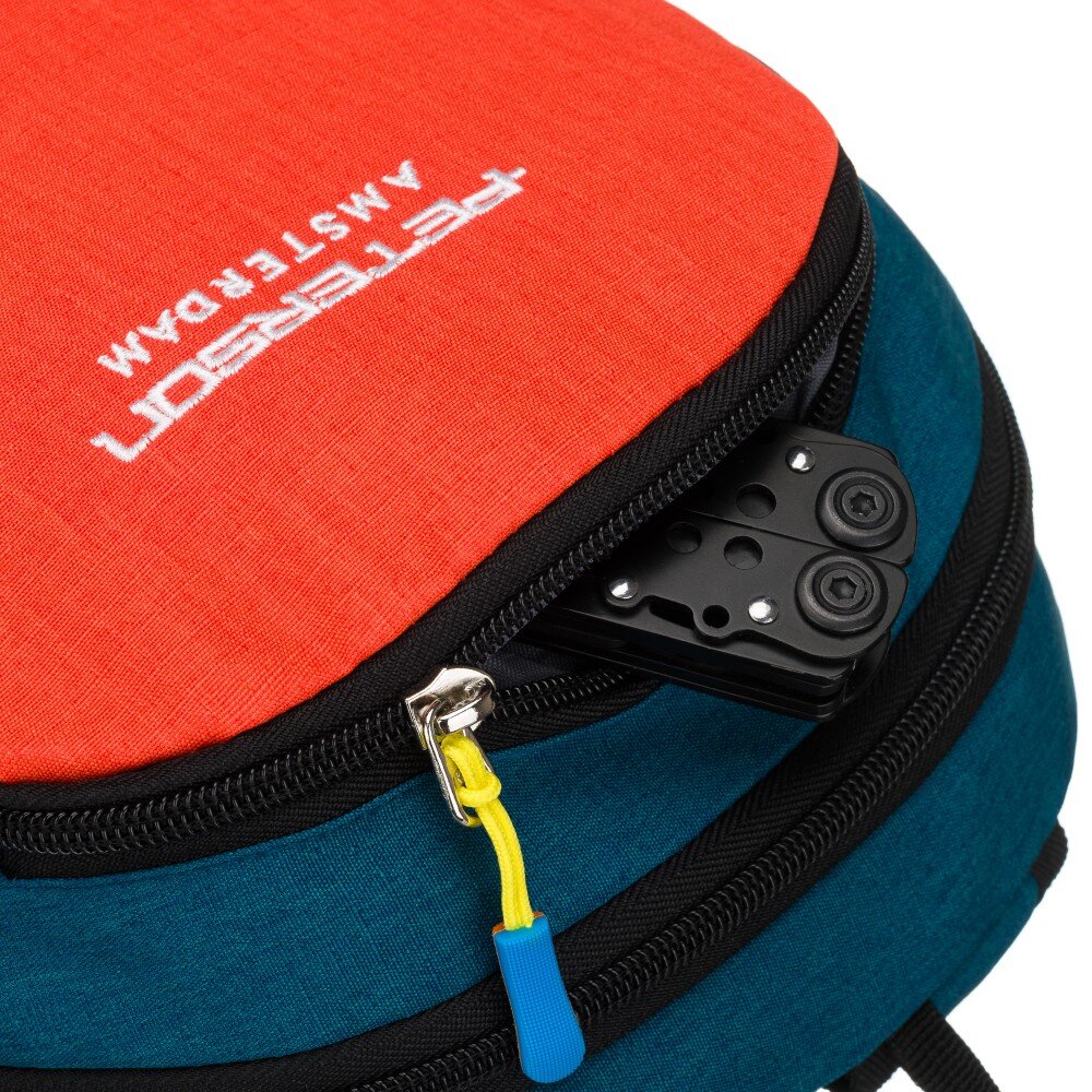 Plecak sportowy w kolorach granatowym i pomarańczowym z widocznym logo \'PETERSON AMSTERDAM\'. Zamek błyskawiczny z żółtym uchwytem jest częściowo otwarty, ukazując czarny przedmiot wewnątrz.