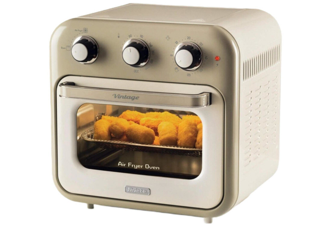 Beżowy mini piekarnik z trzema pokrętłami na górze i przezroczystymi drzwiczkami, za którymi widać pieczone jedzenie. Na drzwiczkach widnieje napis \'Vintage\' oraz \'Air Fryer Oven\', a poniżej logo \'Ariete\'.