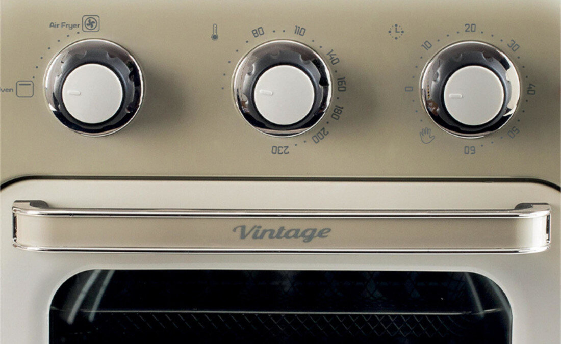 Obraz przedstawia panel sterowania mini piekarnika z trzema pokrętłami i napisem \'Vintage\' na uchwycie. Widoczne są oznaczenia temperatury i czasu oraz symbol \'Air Fryer\'.
