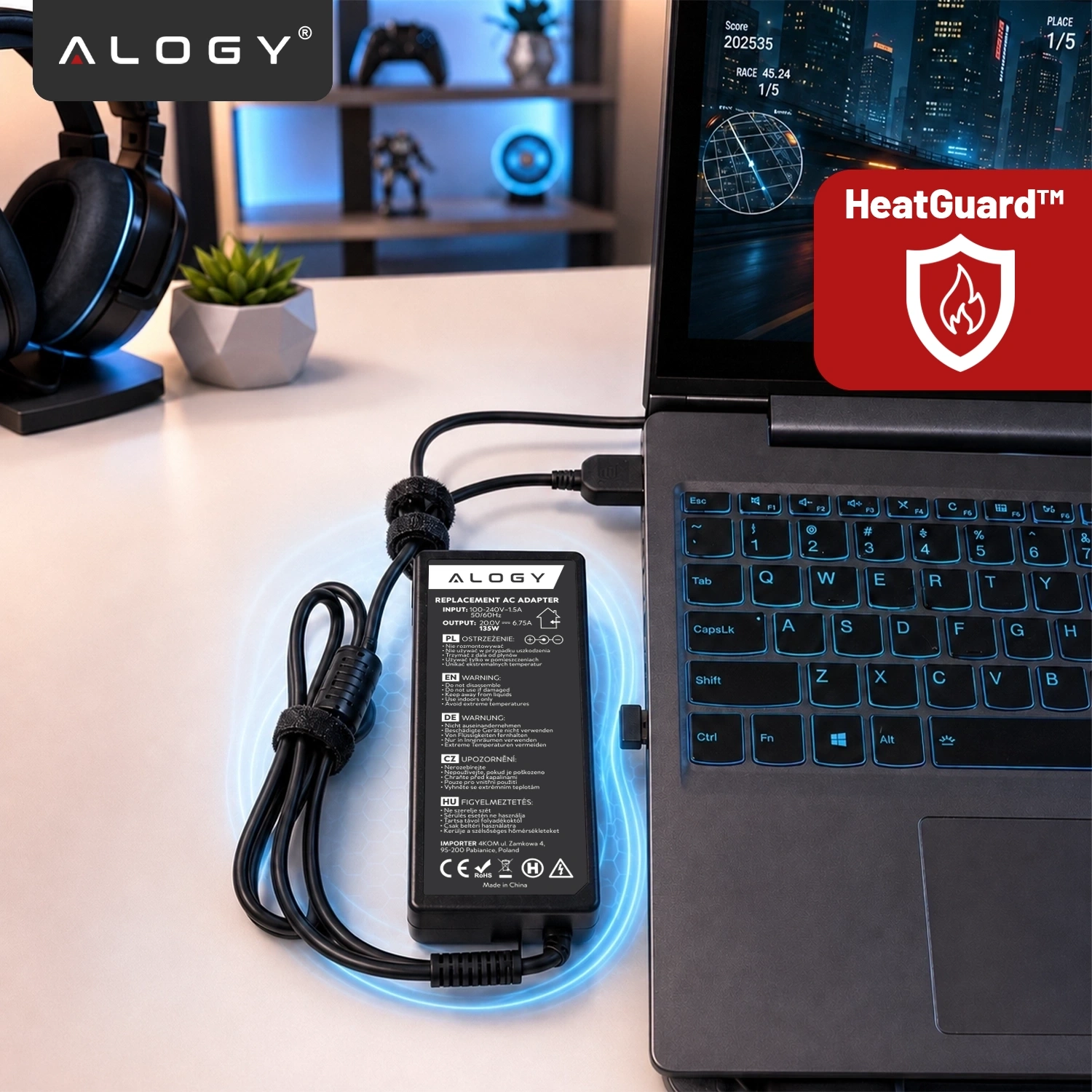 Na biurku znajduje się laptop z podłączonym zasilaczem marki Alogy. Obok widoczny jest czerwony symbol HeatGuard™ z ikoną płomienia.