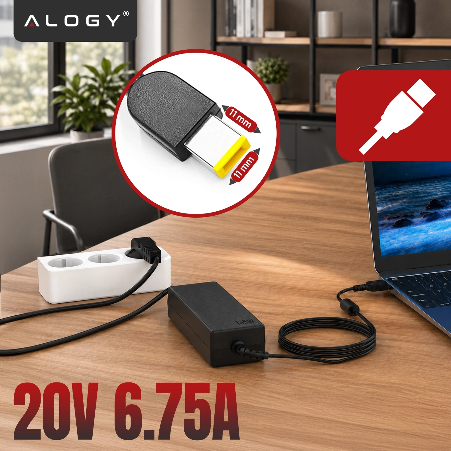 Na drewnianym stole znajduje się zasilacz do laptopa podłączony do gniazdka elektrycznego oraz laptopa. Widoczny jest napis \'20V 6.75A\' oraz logo \'ALOGY\'.