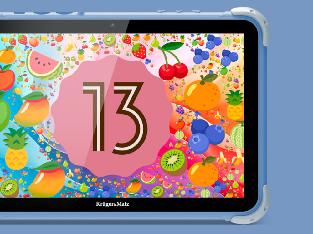 Tablet z kolorowym ekranem przedstawiającym różnorodne owoce oraz dużą liczbę \'13\' na różowym tle. Na obudowie widoczne jest logo \'Krüger&Matz\'.