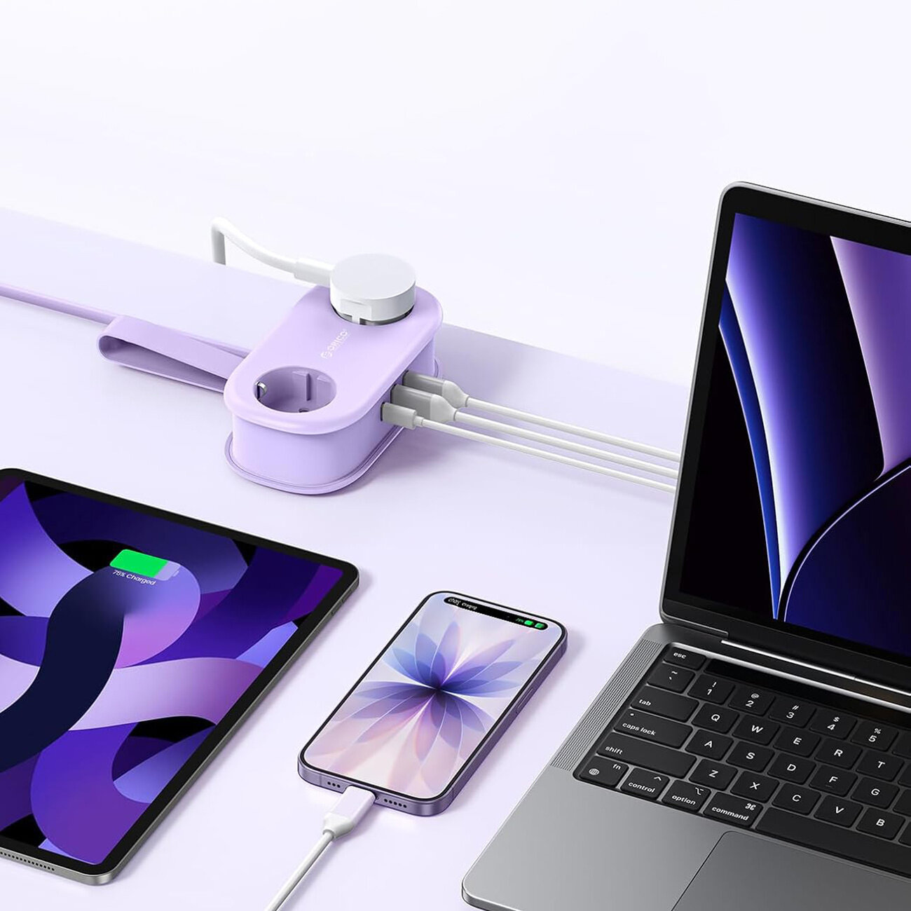 Na obrazie widoczna jest fioletowa listwa zasilająca z kilkoma podłączonymi urządzeniami elektronicznymi, w tym laptopem, tabletem i smartfonem. Listwa posiada gniazda AC oraz porty USB-A i USB-C.