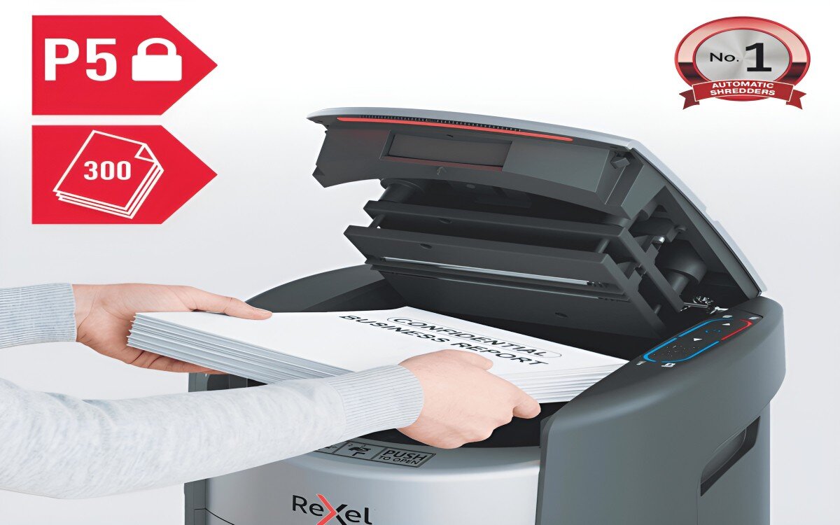 Osoba wkłada stos papierów do niszczarki z widocznym napisem 'CONFIDENTIAL BUSINESS REPORT'. Na urządzeniu widoczne jest logo Rexel.