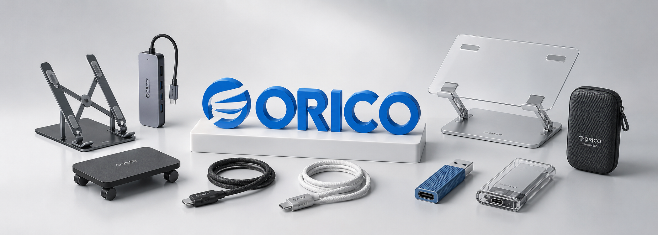 Na obrazie znajduje się zestaw akcesoriów komputerowych, w tym stojaki, kable, adaptery i etui, z widocznym logo \'ORICO\'. Produkty są rozmieszczone na jasnym tle, a centralnie umieszczony jest napis \'ORICO\'.