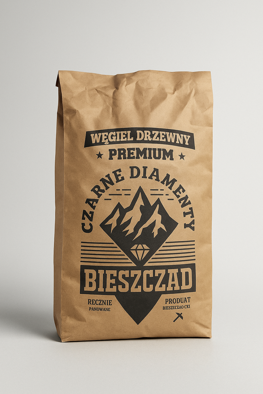 Brązowy papierowy worek z nadrukiem \'Węgiel Drzewny Premium Czarne Diamenty Bieszczad\'. Widoczne są również napisy \'Ręcznie Panowane\' oraz \'Produkt Bieszczadzki\'.