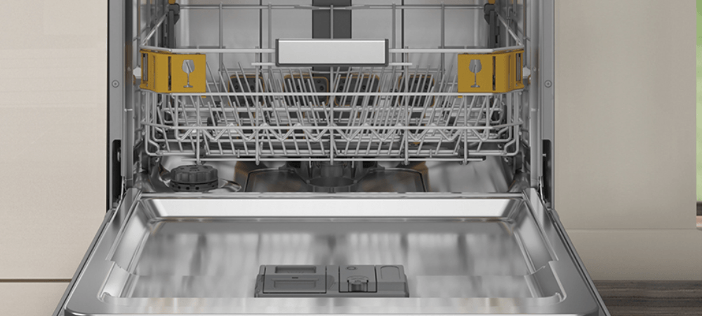 ZMYWARKA WHIRLPOOL WH6FTA14B1N6WX Wnętrze otwartej zmywarki Whirlpool z widocznym dolnym koszem. Po bokach kosza znajdują się żółte oznaczenia z symbolem kieliszka Aquastop Opóźnienie startu Program samoczyszczenia