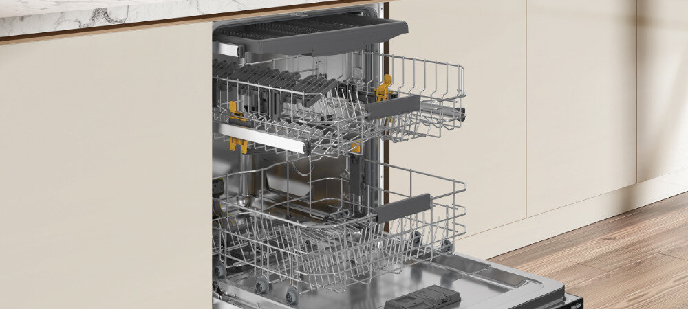 ZMYWARKA WHIRLPOOL WH6ITD14C6N6 Otwarta zmywarka Whirlpool z wysuniętymi koszami i szufladą na sztućce. Widoczne są żółte elementy regulacyjne oraz uchwyty w koszach stal nierdzewna chromowane uchwyty