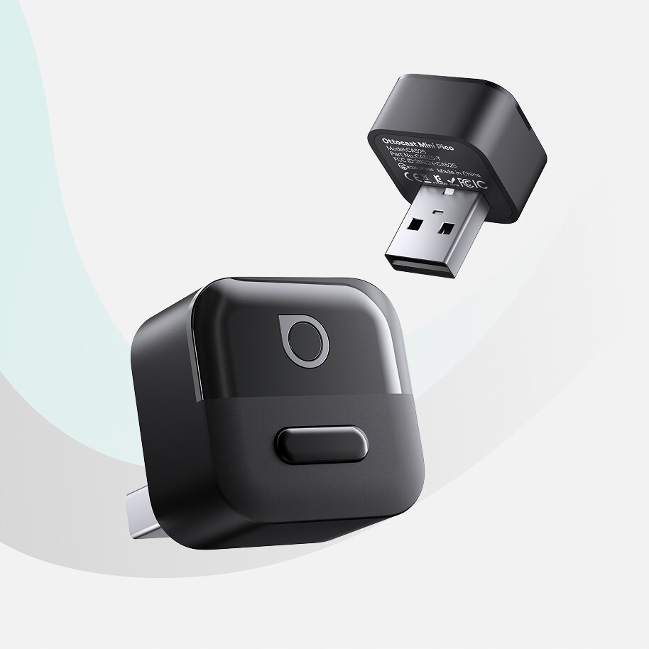 Na obrazie widoczny jest czarny adapter USB z zaokrąglonymi krawędziami i przyciskiem na obudowie. Na mniejszym adapterze widoczny jest tekst: \'Ottocast Mini Pico\'.