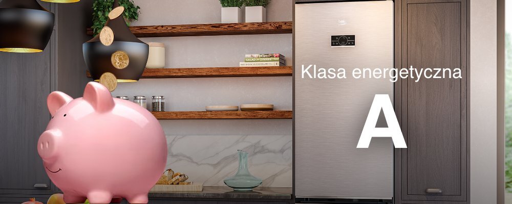 W kuchni znajduje się lodówka w kolorze inox, obok której widnieje napis \'Klasa energetyczna A\'. Na pierwszym planie stoi różowa skarbonka w kształcie świnki, a w tle widać drewniane półki z dekoracjami.