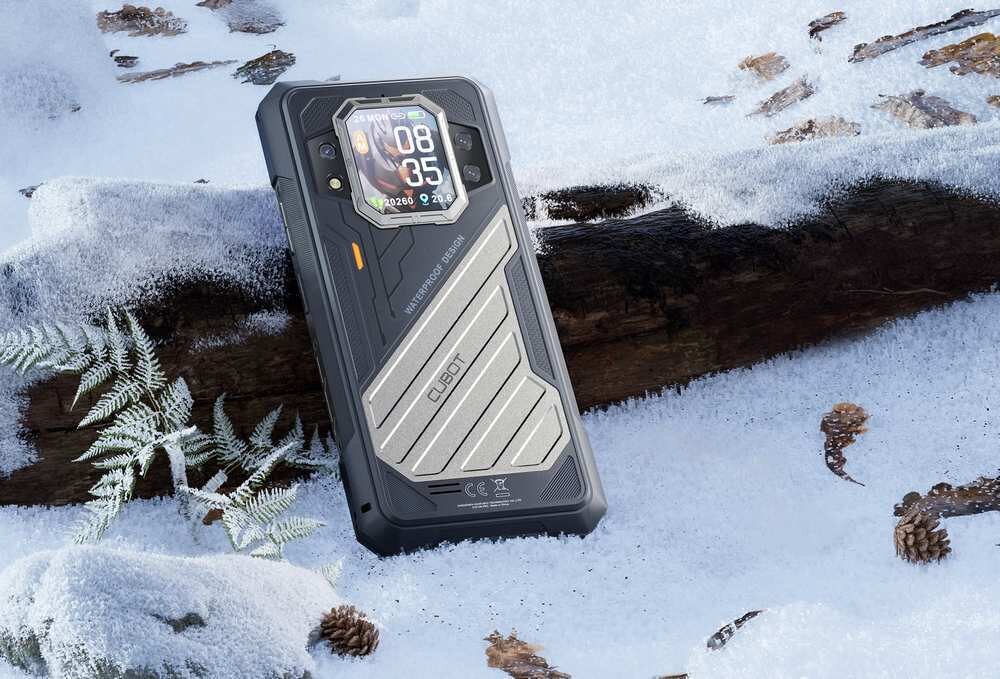Smartfon z wyświetlaczem na tylnej obudowie leży na śniegu obok gałęzi i szyszek. Na obudowie widoczne są napisy: \'CUBOT\' oraz \'WWW.CUBOT.NET\'.