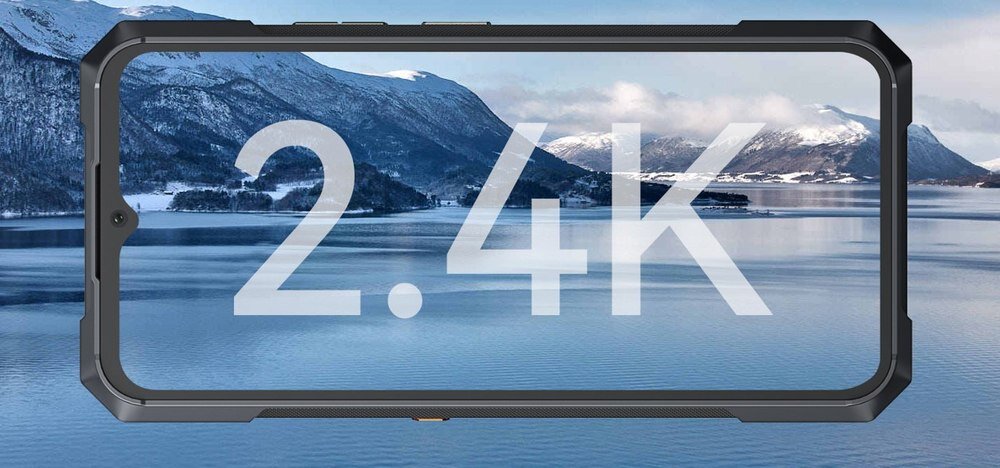 Obraz przedstawia smartfon z wyświetlaczem, na którym widoczny jest krajobraz górski z jeziorem. Na ekranie znajduje się duży napis \'2.4K\'.