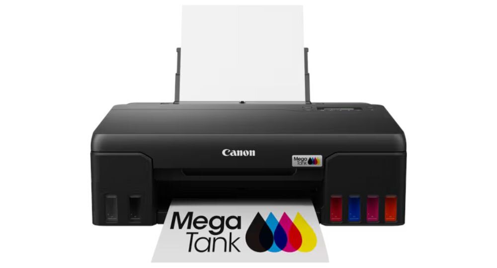 Czarna drukarka z logo Canon i MegaTank, z widocznymi kolorowymi zbiornikami na tusz. Przed drukarką znajduje się wydruk z napisem \'Mega Tank\' i kolorowymi kroplami tuszu.