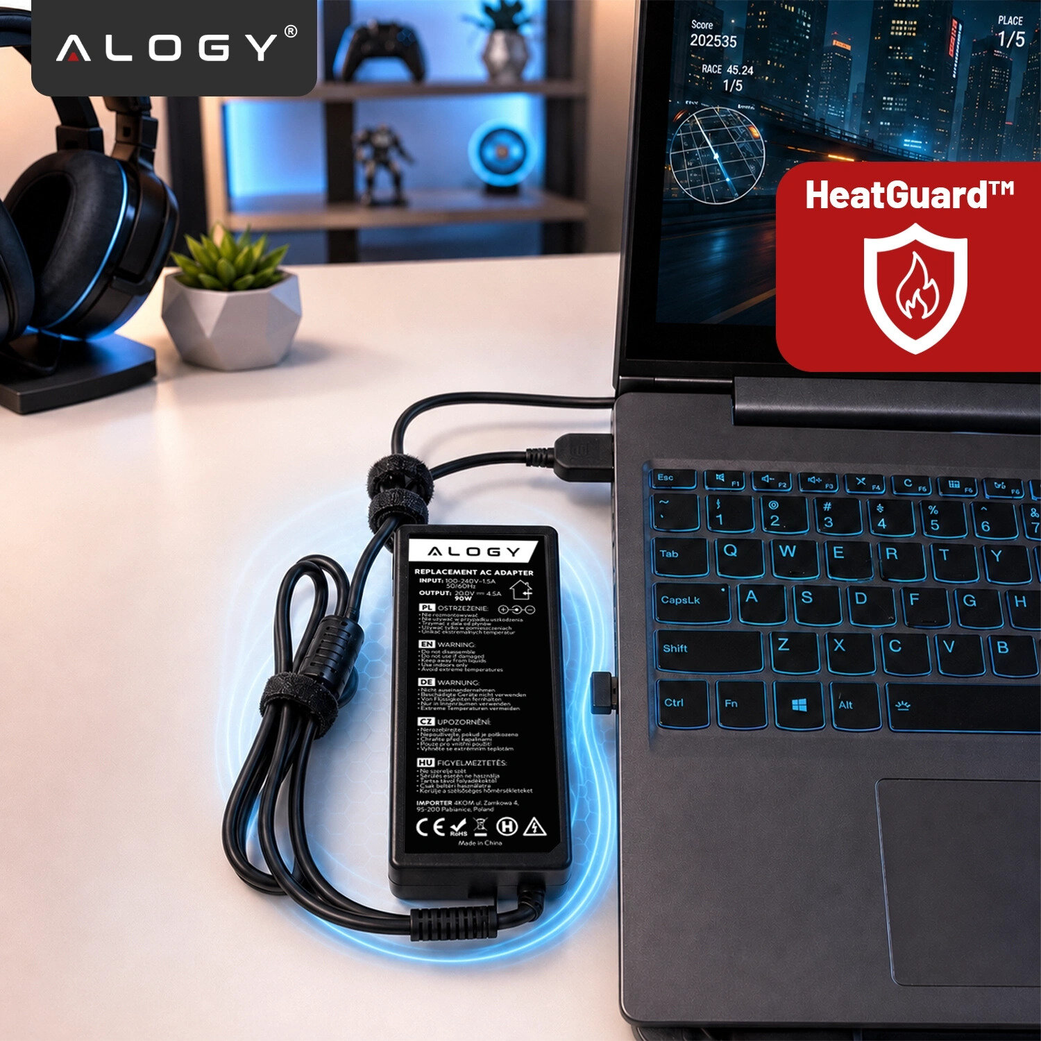 Na biurku znajduje się laptop z podłączonym zasilaczem marki Alogy. Obok widoczny jest czerwony symbol HeatGuard™ z ikoną płomienia.