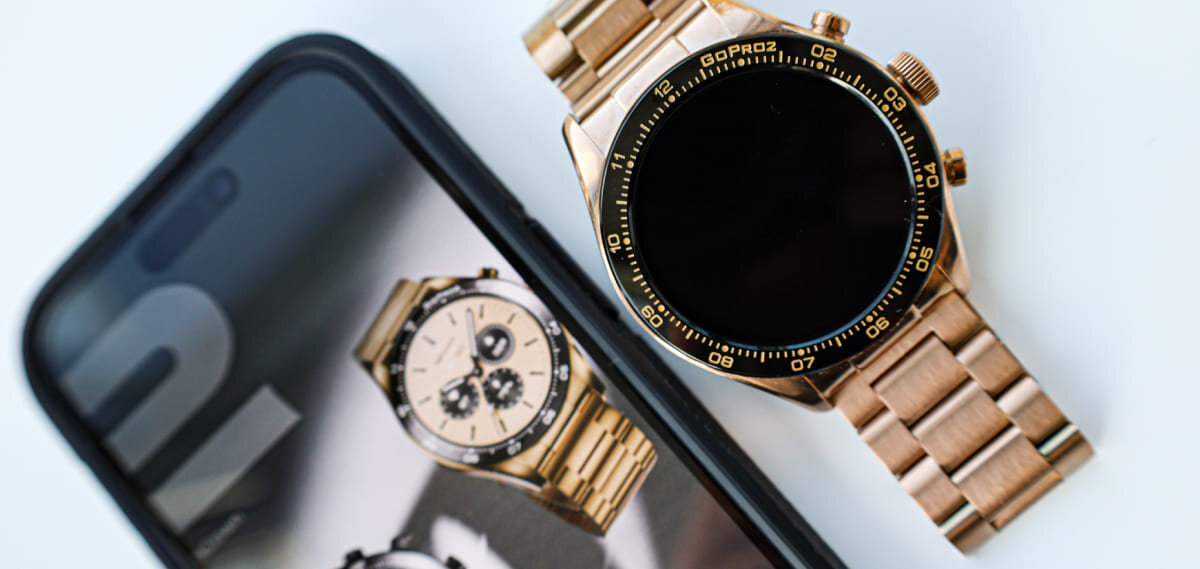 HiFuture Go Pro 2 Black Gold obok telefonu z jego odbiciem na ekranie.