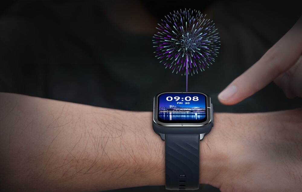 Osoba nosi czarny smartwatch z wyświetlaczem pokazującym godzinę 09:08 i datę Fri 20. Nad zegarkiem widoczna jest grafika fajerwerków.