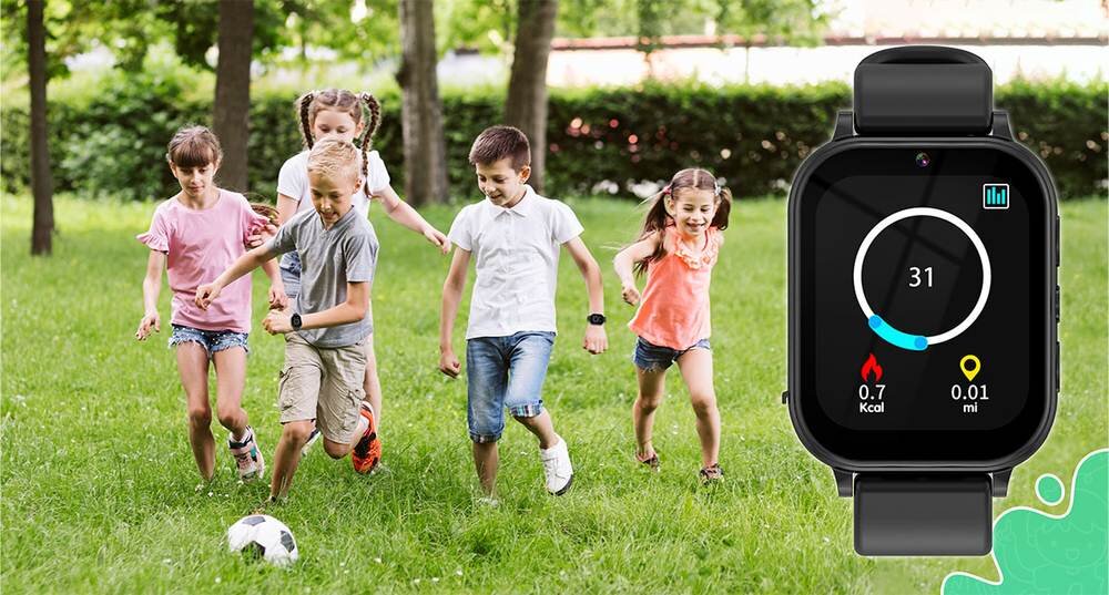 Grupa dzieci bawi się na trawie z piłką, a obok widoczny jest czarny smartwatch z wyświetlaczem pokazującym 31, 0.7 Kcal i 0.01 mi.