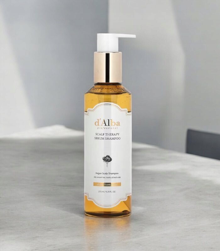 Butelka z pompką zawierająca produkt d\'Alba professional Scalp Therapy Serum Shampoo o pojemności 275 ml. Etykieta jest biała z czarnym tekstem i złotymi akcentami.