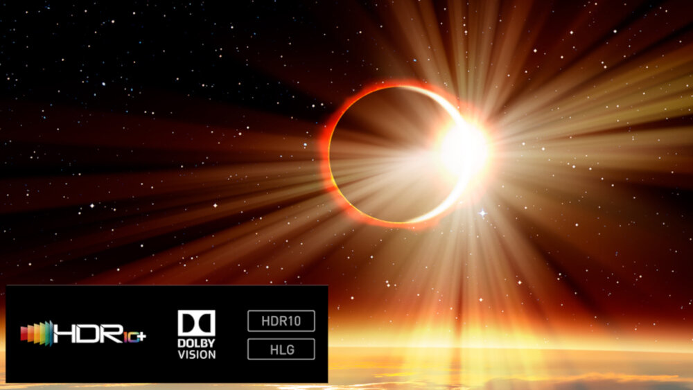 Obraz przedstawia zaćmienie słońca z promieniami światła rozchodzącymi się na boki. W lewym dolnym rogu widoczne są logotypy HDR10+, Dolby Vision, HDR10 i HLG.