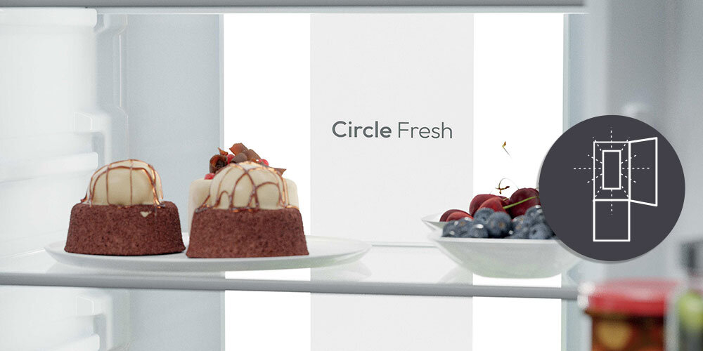 Wnętrze lodówki z dwoma deserami na talerzu oraz owocami. Widoczny napis \'Circle Fresh\' i symbol otwartych drzwi.