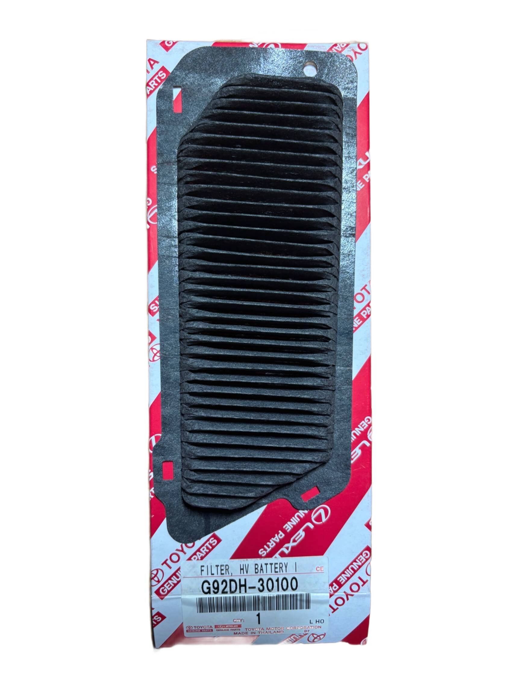 Na obrazie widoczny jest czarny filtr o prostokątnym kształcie z falistą powierzchnią, umieszczony na tle z logo Toyota. Na dole widnieje napis: \'FILTER, HV BATTERY G92DH-30100\'.