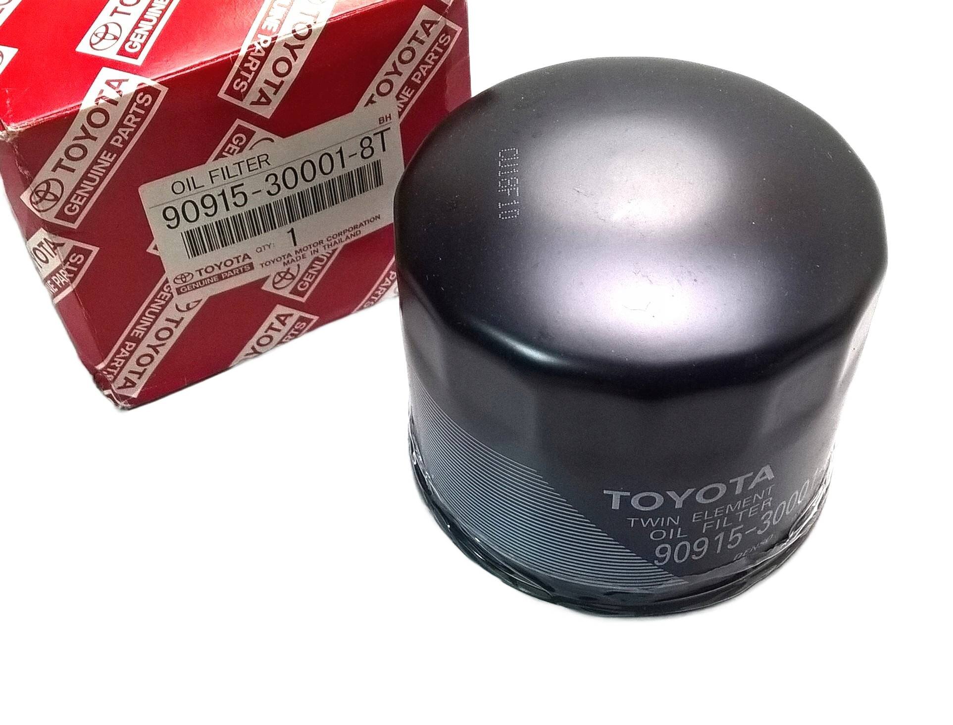 Na obrazie widoczny jest czarny filtr oleju z napisem \'TOYOTA TWIN ELEMENT OIL FILTER 90915-30002\' oraz czerwone pudełko z logo \'TOYOTA GENUINE PARTS\' i etykietą \'OIL FILTER 90915-30001-8T\'.