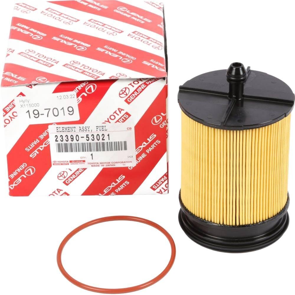 Na obrazie widoczny jest filtr paliwa z czarną podstawą i żółtym korpusem, obok znajduje się pudełko z logo Toyota i Lexus oraz napisami \'ELEMENT ASSY, FUEL 23390-53021\'.