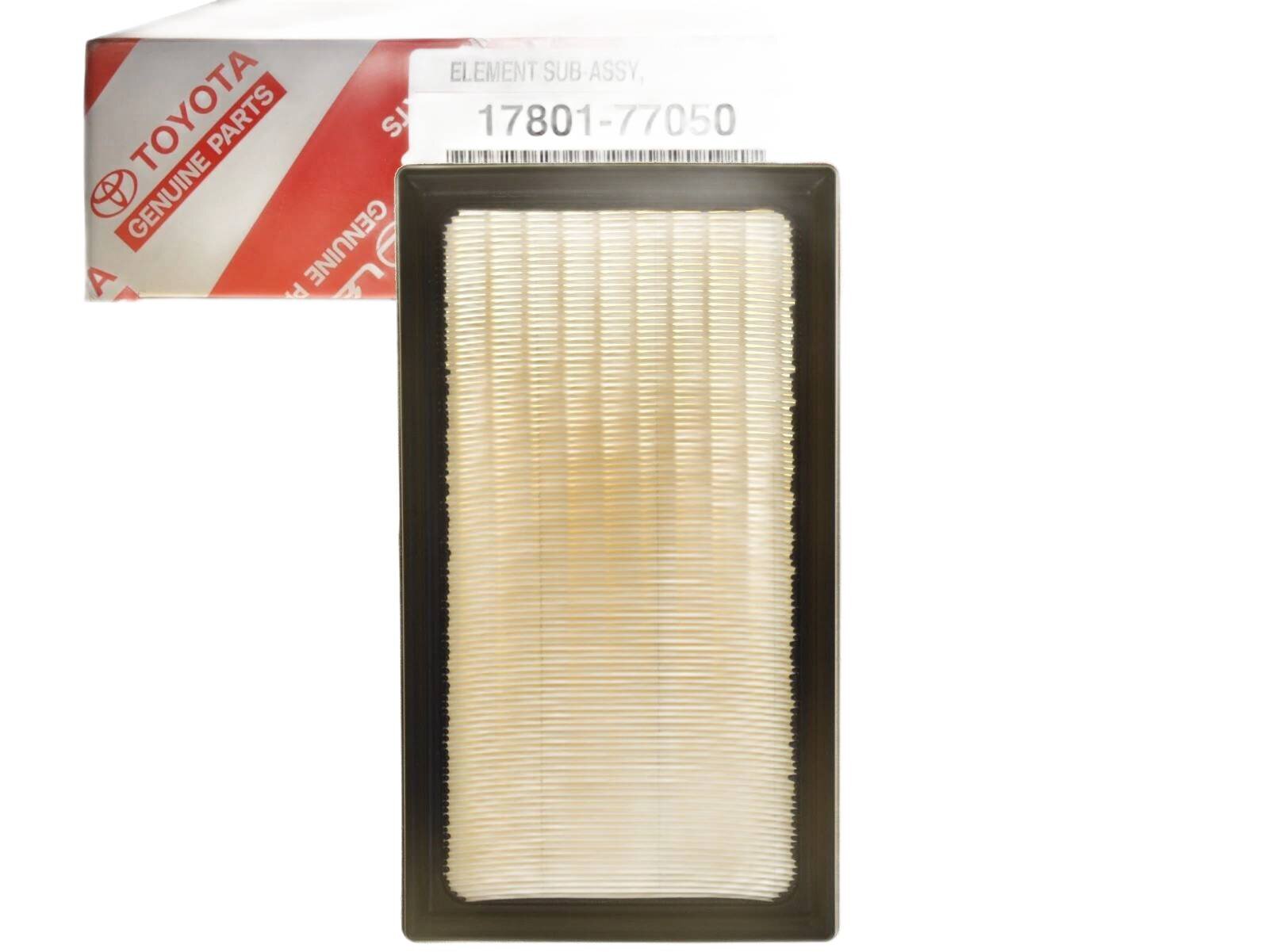 Na obrazie widoczny jest prostokątny filtr powietrza z białym materiałem filtrującym i czarną ramką. W tle znajduje się opakowanie z logo \'TOYOTA GENUINE PARTS\' oraz numerem \'17801-77050\'.