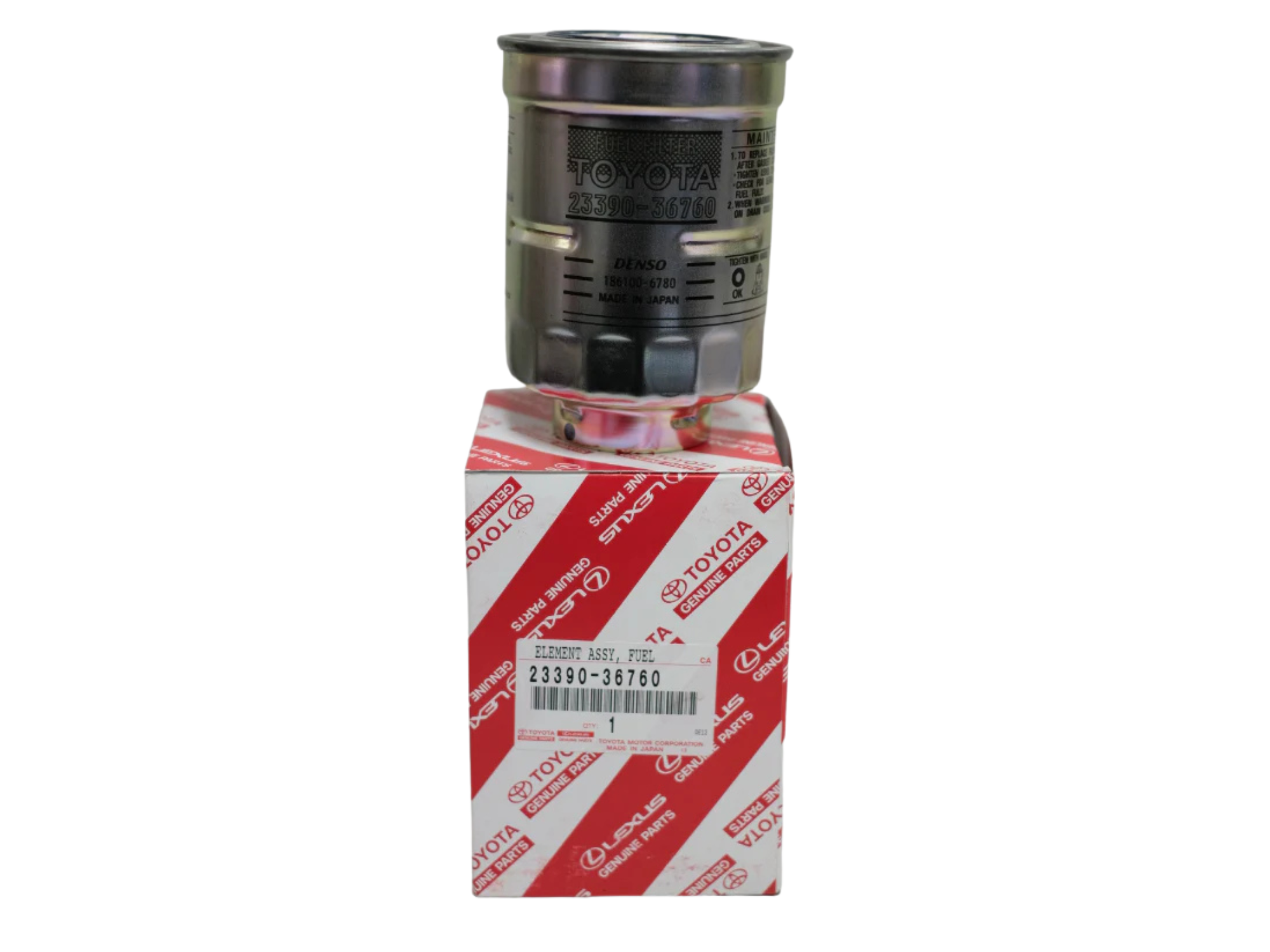 Na obrazie widoczny jest metalowy filtr paliwa z napisem \'TOYOTA 23390-36760\', umieszczony na pudełku z czerwonym wzorem i logo \'TOYOTA\'.