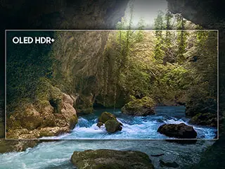 320x240-oled-hdr Obraz przedstawia krajobraz z rzeką płynącą przez skalisty teren, otoczony bujną roślinnością. W lewym górnym rogu widoczny jest napis \'OLED HDR+\'.