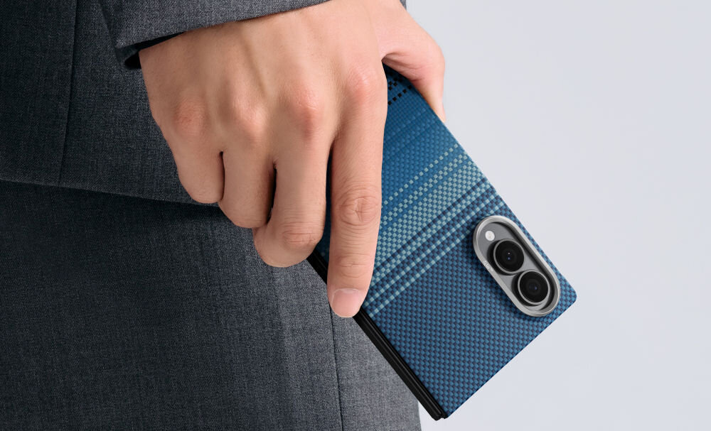 Osoba trzyma telefon w niebieskim etui z teksturą, które ma dwa widoczne obiekty przypominające obiektywy aparatu.