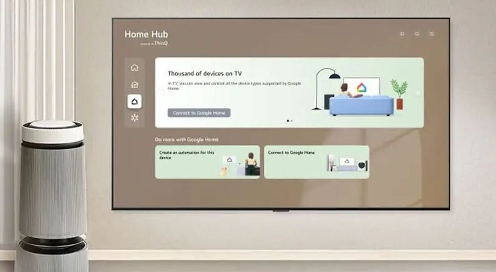 Na ścianie wisi duży telewizor z wyświetlonym interfejsem \'Home Hub\' i opcjami związanymi z Google Home. Obok telewizora stoi nowoczesny głośnik lub urządzenie domowe.