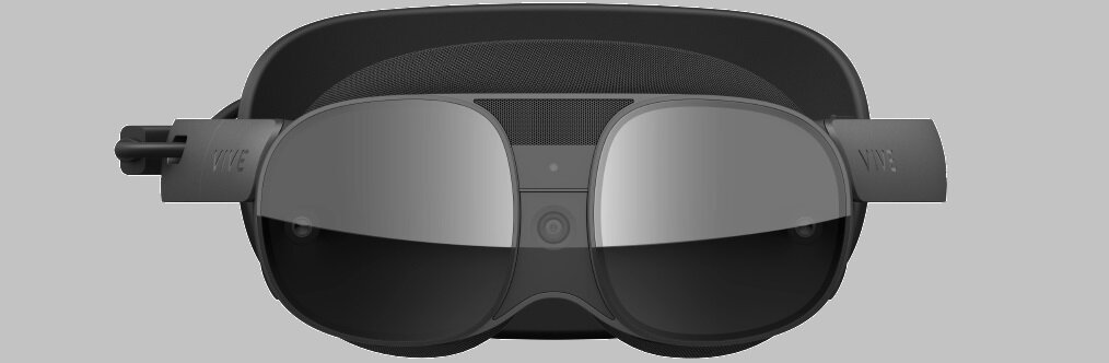 Na obrazie widoczne są gogle VR z ciemnymi szkłami i logo \'VIVE\' na opaskach bocznych. Gogle mają nowoczesny design z centralnie umieszczonym przyciskiem lub czujnikiem.