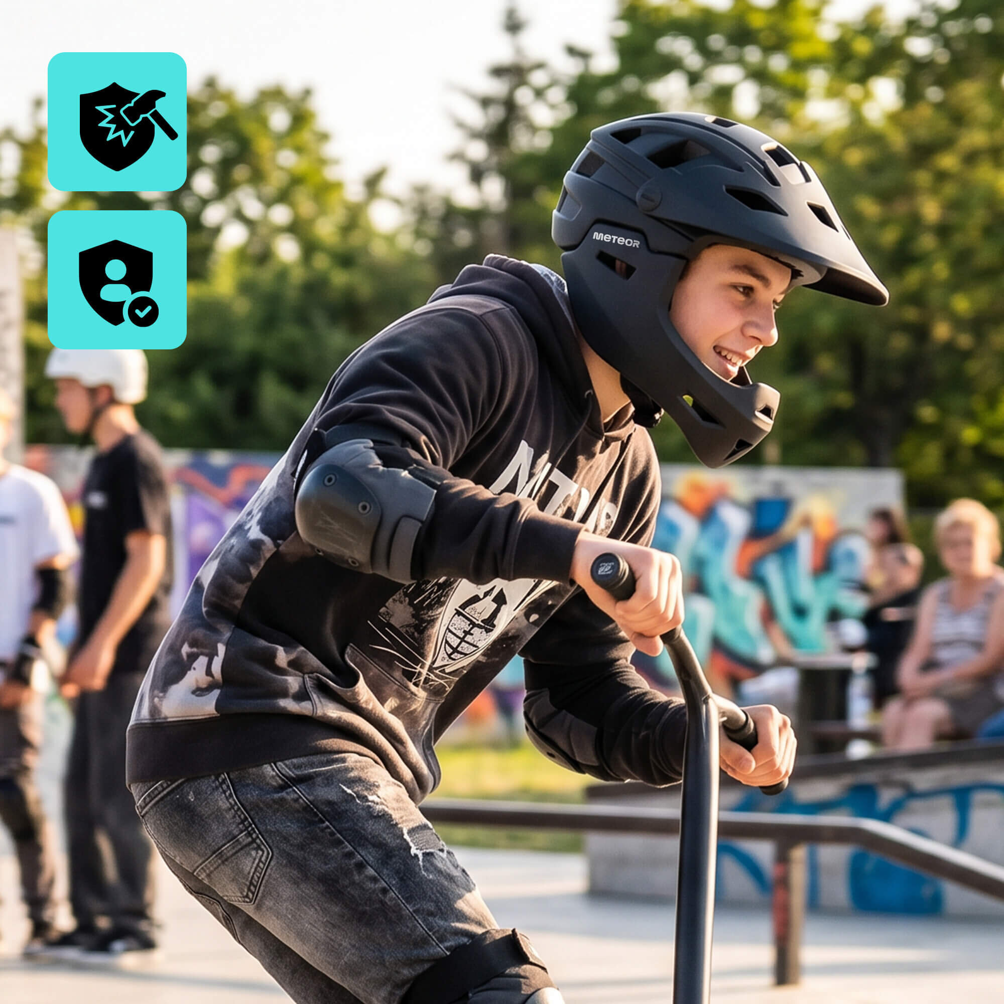 Osoba w czarnym kasku rowerowym full-face marki METEOR jedzie na hulajnodze w skateparku. W tle widoczne są inne osoby oraz graffiti na murze.