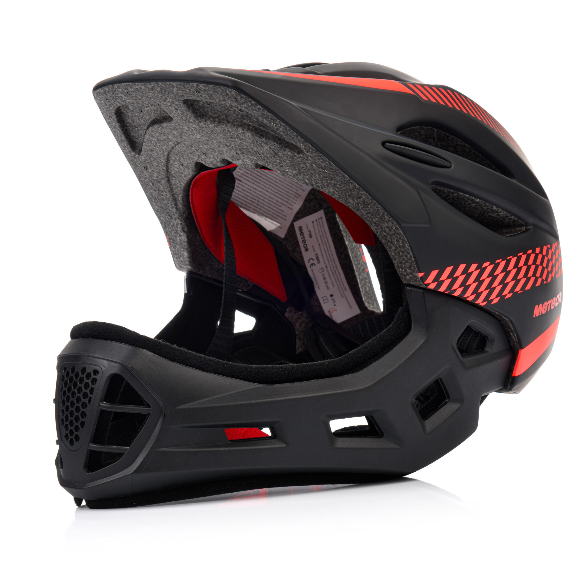 Czarny kask rowerowy full-face z czerwonymi akcentami i wzorem szachownicy. Widoczne logo \'METEOR\' na boku kasku.