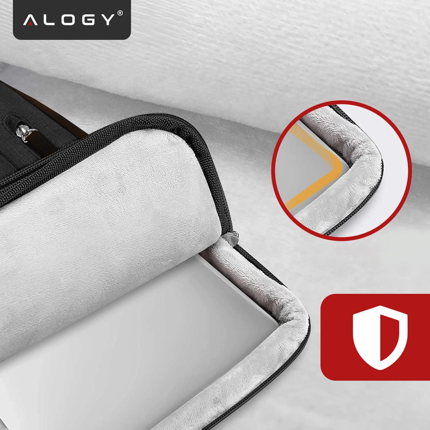 Na obrazie widoczny jest czarny pokrowiec na laptopa z miękkim, jasnym wnętrzem. W lewym górnym rogu znajduje się logo \'ALOGY\', a w prawym dolnym rogu czerwony symbol tarczy.