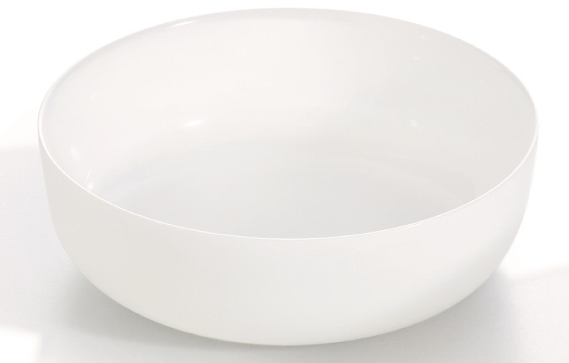 Na obrazie widoczna jest biała, okrągła miska o gładkiej powierzchni. Miska ma prosty, minimalistyczny design.