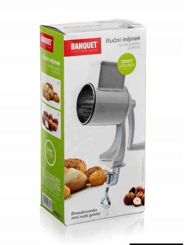 Opakowanie produktu z maszynką ręczną do mielenia, z widocznym logo \'BANQUET\' i napisem \'Ruční mlýnek na strouhanku a ořechy\'. Na opakowaniu znajdują się zdjęcia orzechów i pieczywa oraz napis \'ČESKÝ VÝROBEK\'.