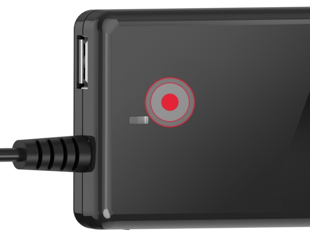 Czarny zasilacz z widocznym portem USB i podłączonym kablem. Na powierzchni znajduje się czerwony okrągły wskaźnik.