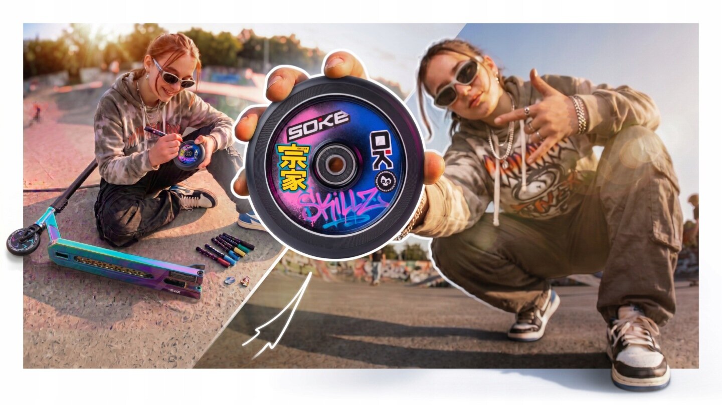 Osoba siedzi na rampie skateparku, trzymając koło hulajnogi z napisem \'SOKE\' i kolorowymi grafikami. Obok leży hulajnoga wyczynowa z szerokim deckiem oraz kilka markerów.